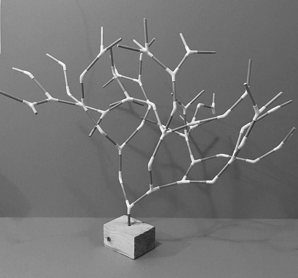 A white branching model rises from a small square base against a grey backdrop